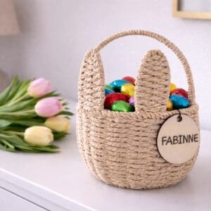 Osterkorb mit Name – geflochtener Korb mit Hasenohren auf weissem Sideboard mit Tulpen und Ostereiern Name Fabienne
